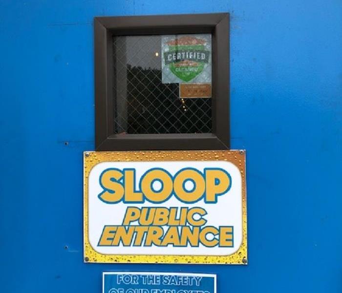 A photo of an entrance door to a brewery displaying the SERVPRO: Certified Cleaned badge