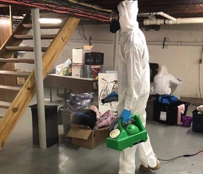 A SERVPRO employee in PPE applying disinfectants to a commercial property