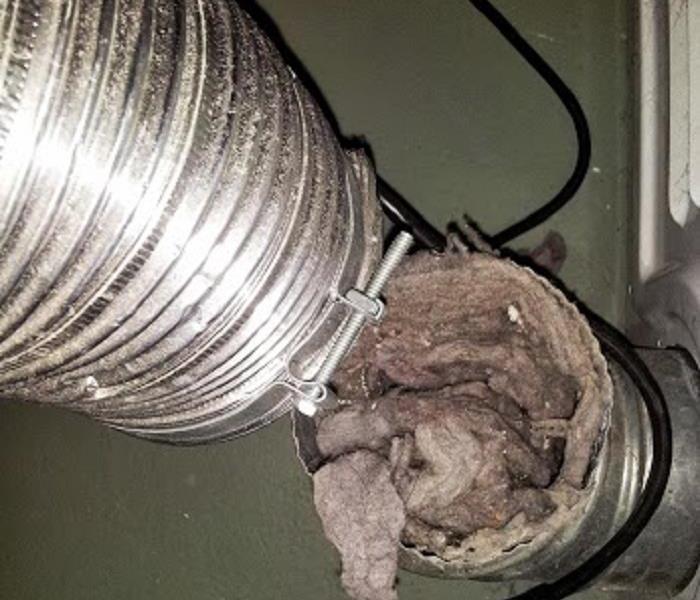 Dust, dirt and debris filled accordion-style dryer vent in a home