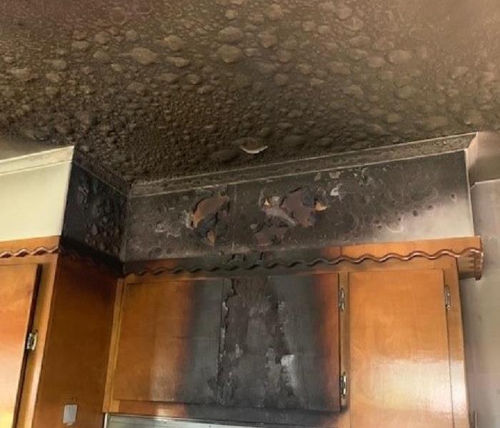 Soot darkened cabinets and a burned kitchen ceiling is the aftermath of this kitchen fire.